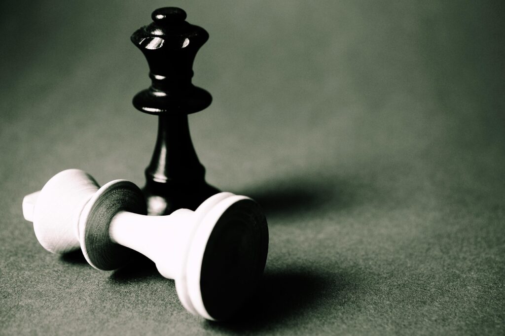 Two chess pieces. One is lying down showing defeat